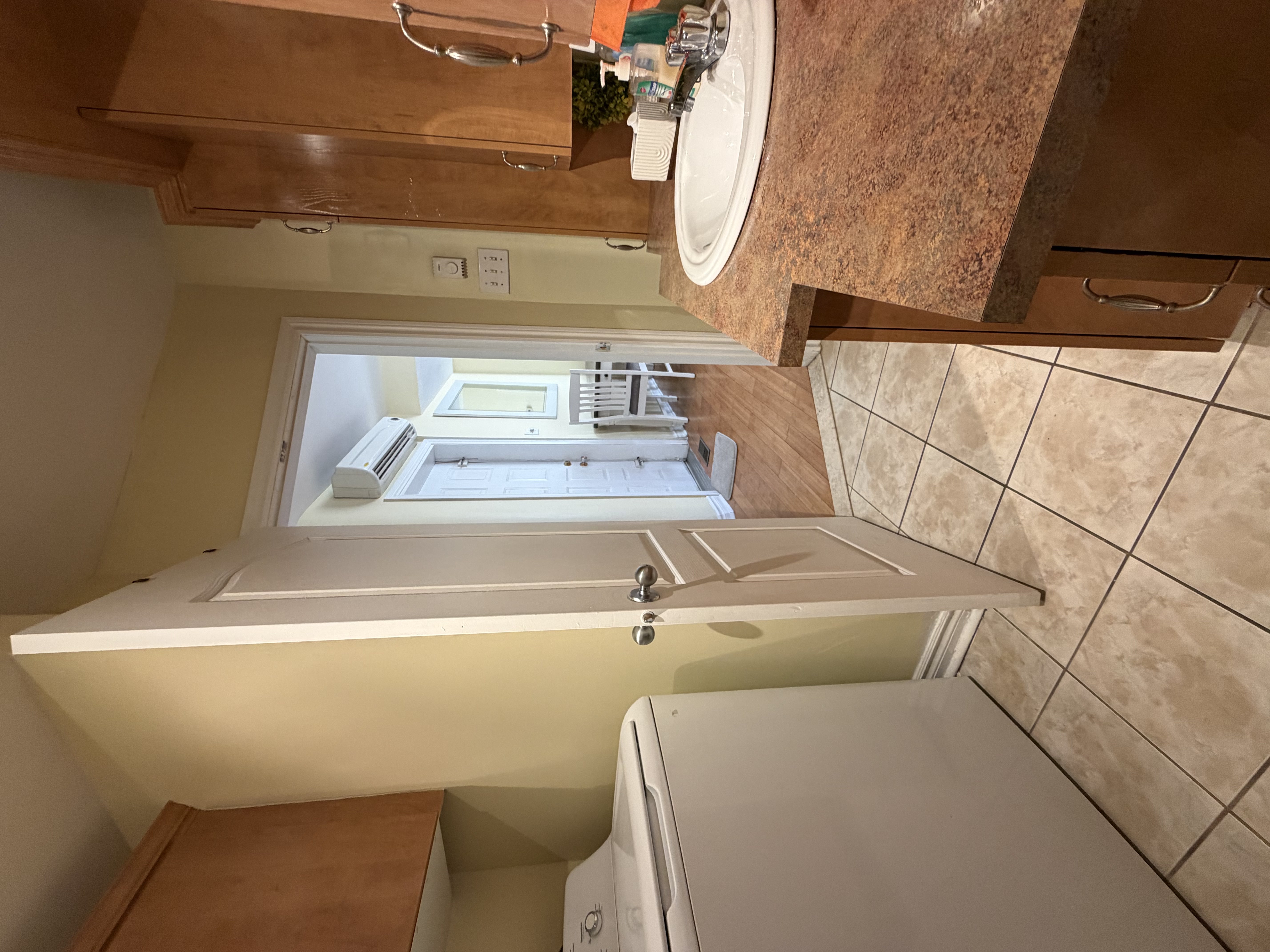 Shared accommodation utility area with washing machine, sink, and bathroom access provided for SonoRAY course participants