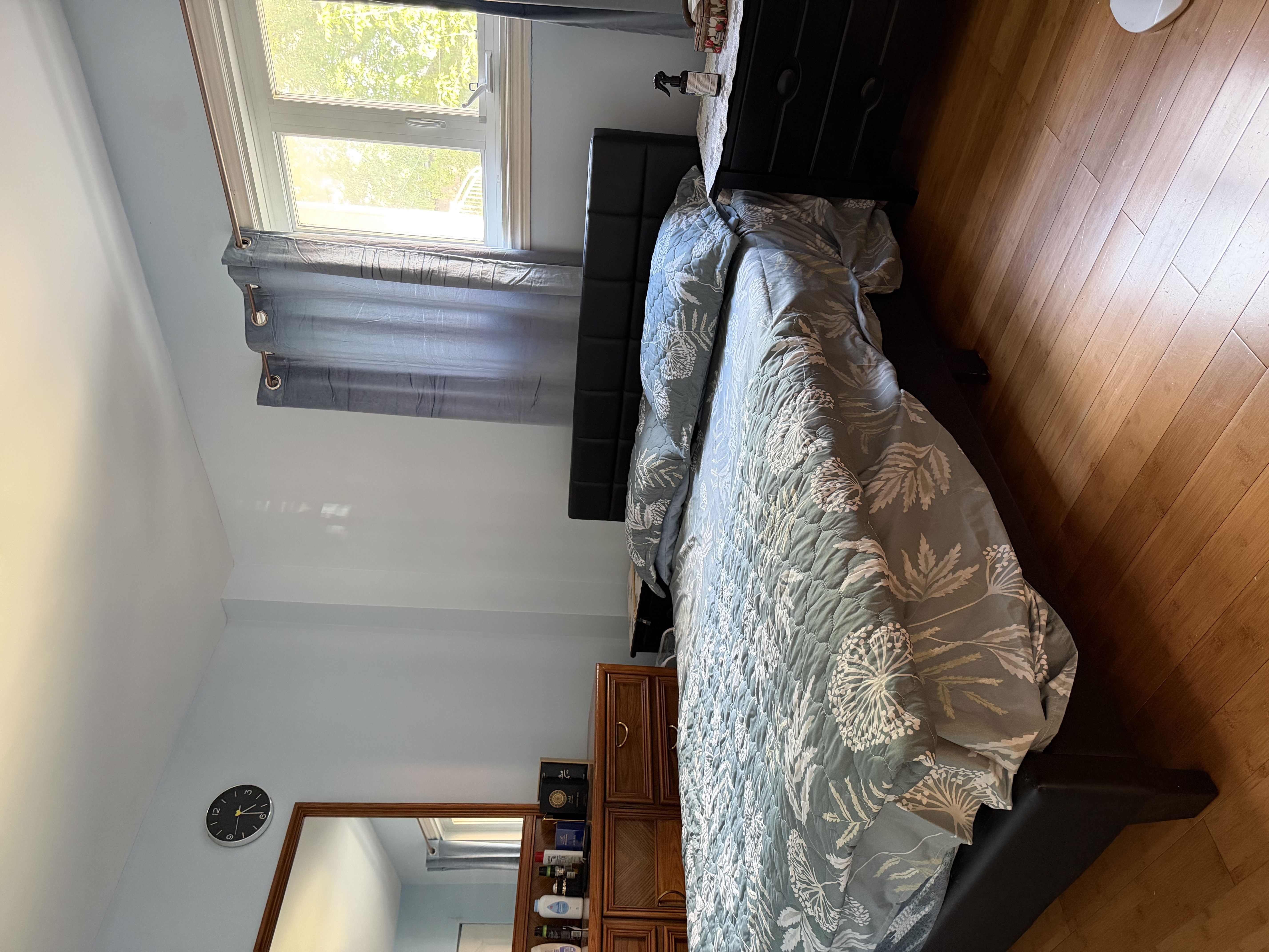 Clean bedroom with double bed, bedside furniture, and natural lighting provided for SonoRAY course participants staying onsite