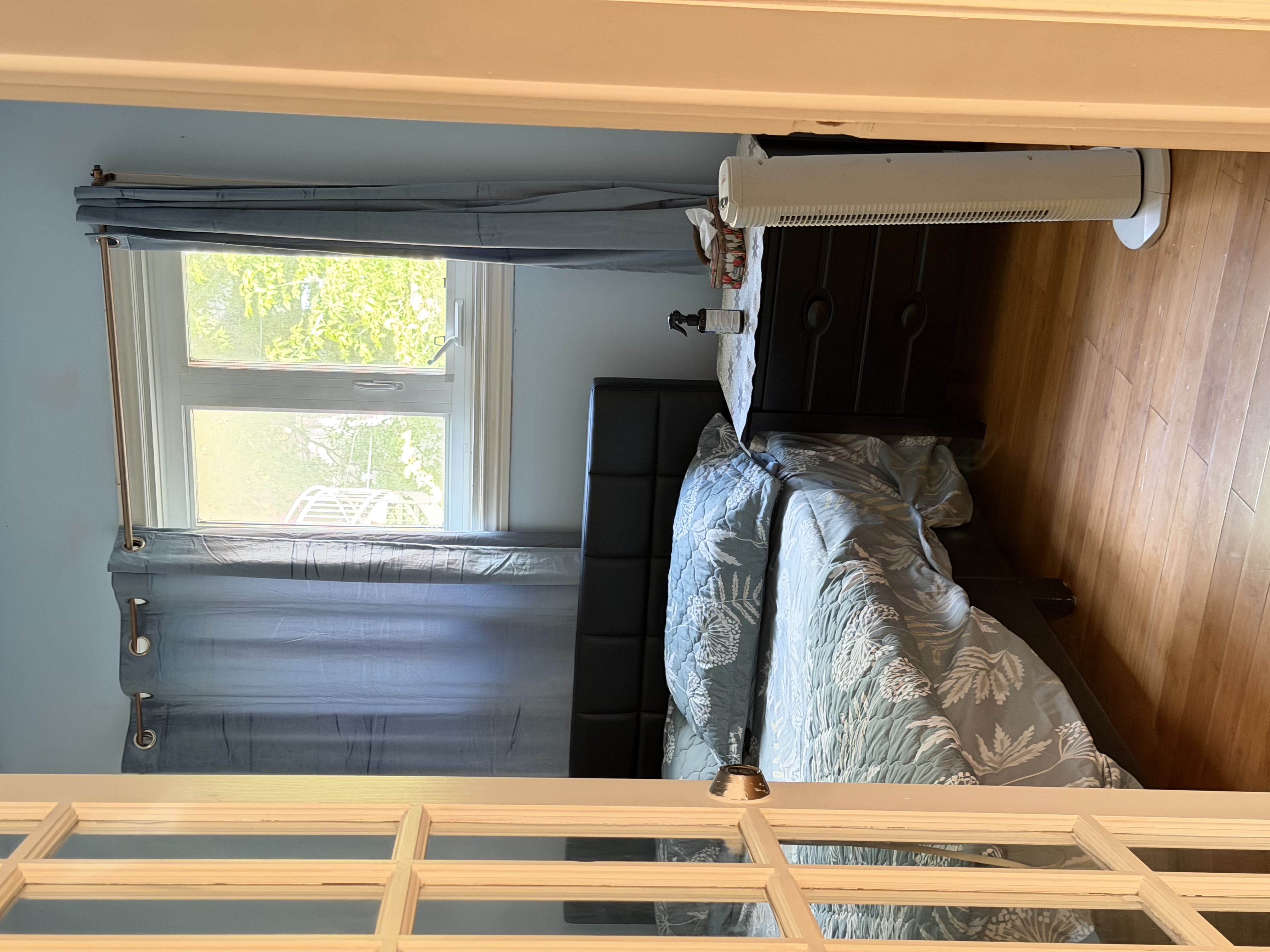 Comfortable bedroom with bed, bedside table, window, and storage space available as part of SonoRAY course accommodation